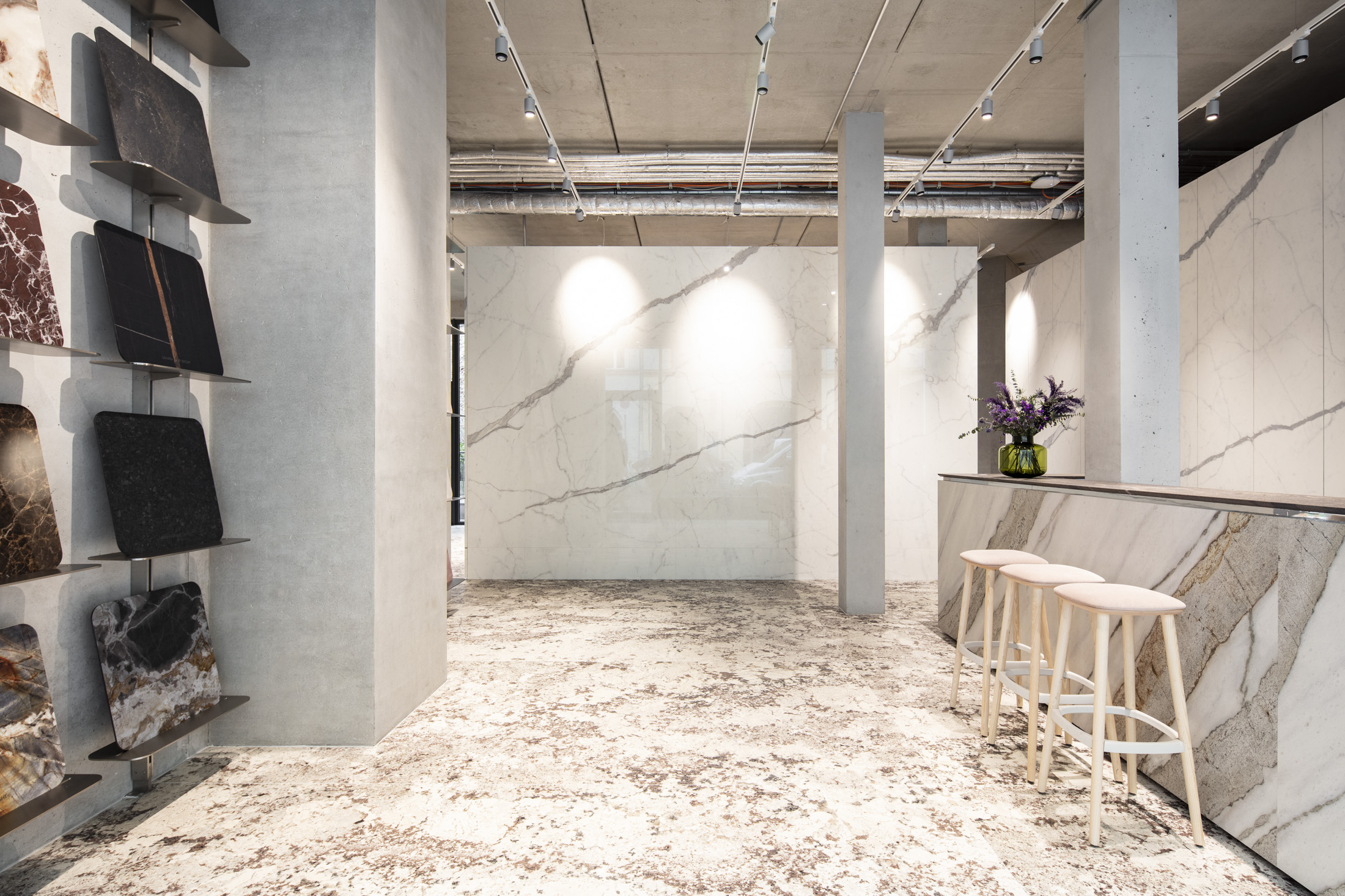 High-quality tile showroom with marble-effect wall tiles, patterned floor, and tile samples.