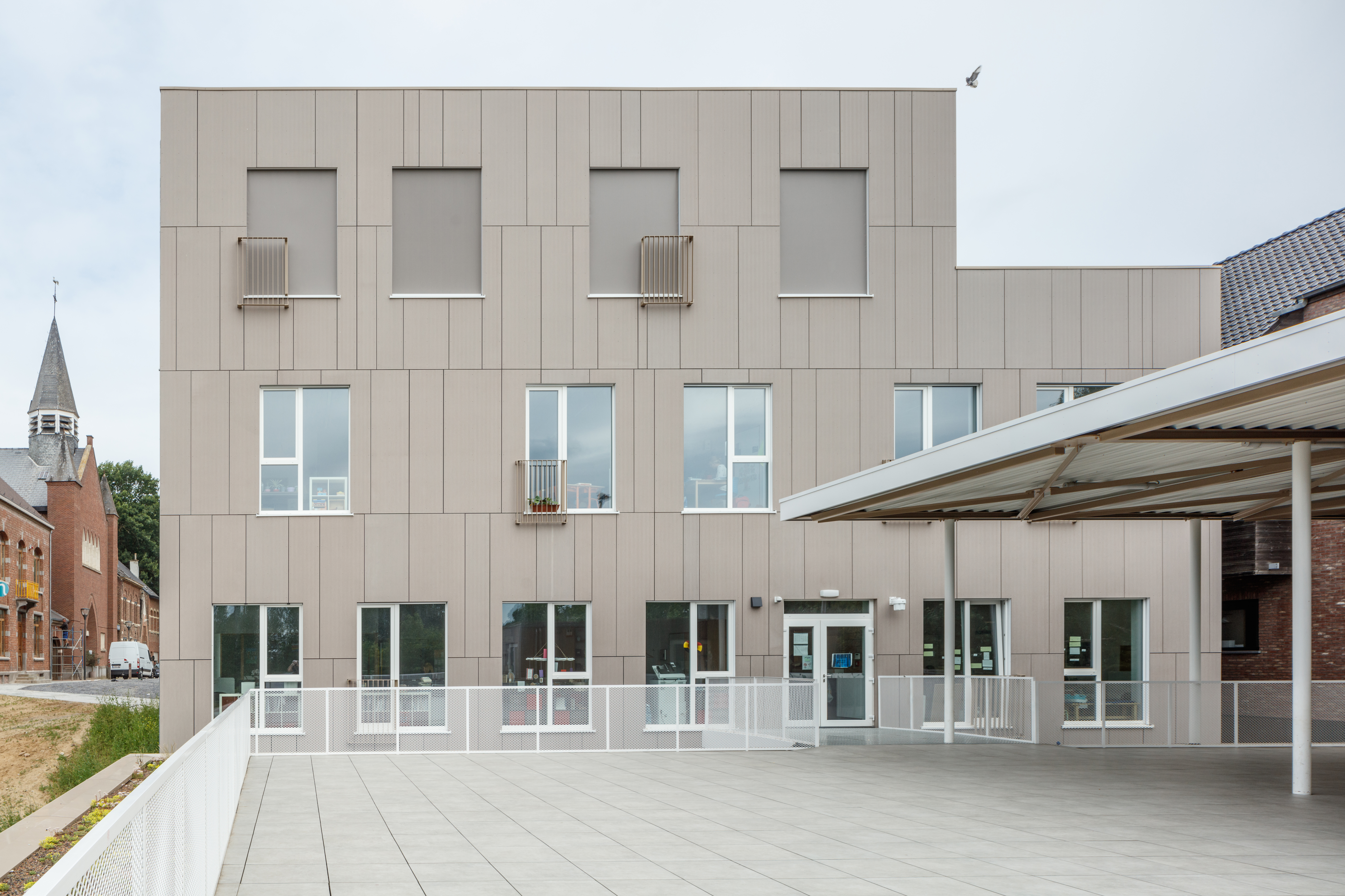 Modern facade with bright outdoor paving made of high-quality tiles.