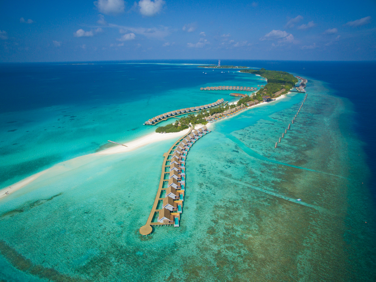 Maldives: Luxurious island resort with overwater villas in the turquoise sea.