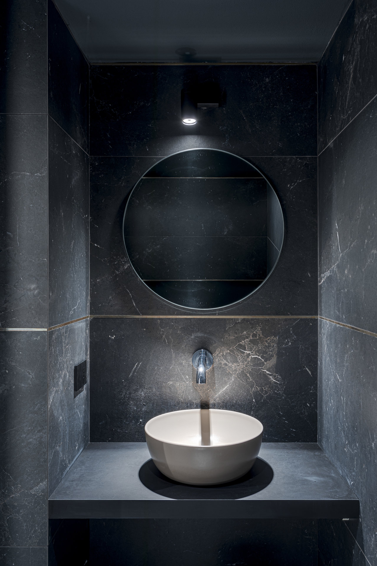 Elegant bathroom with large-format, dark stone-effect tiles and modern design.