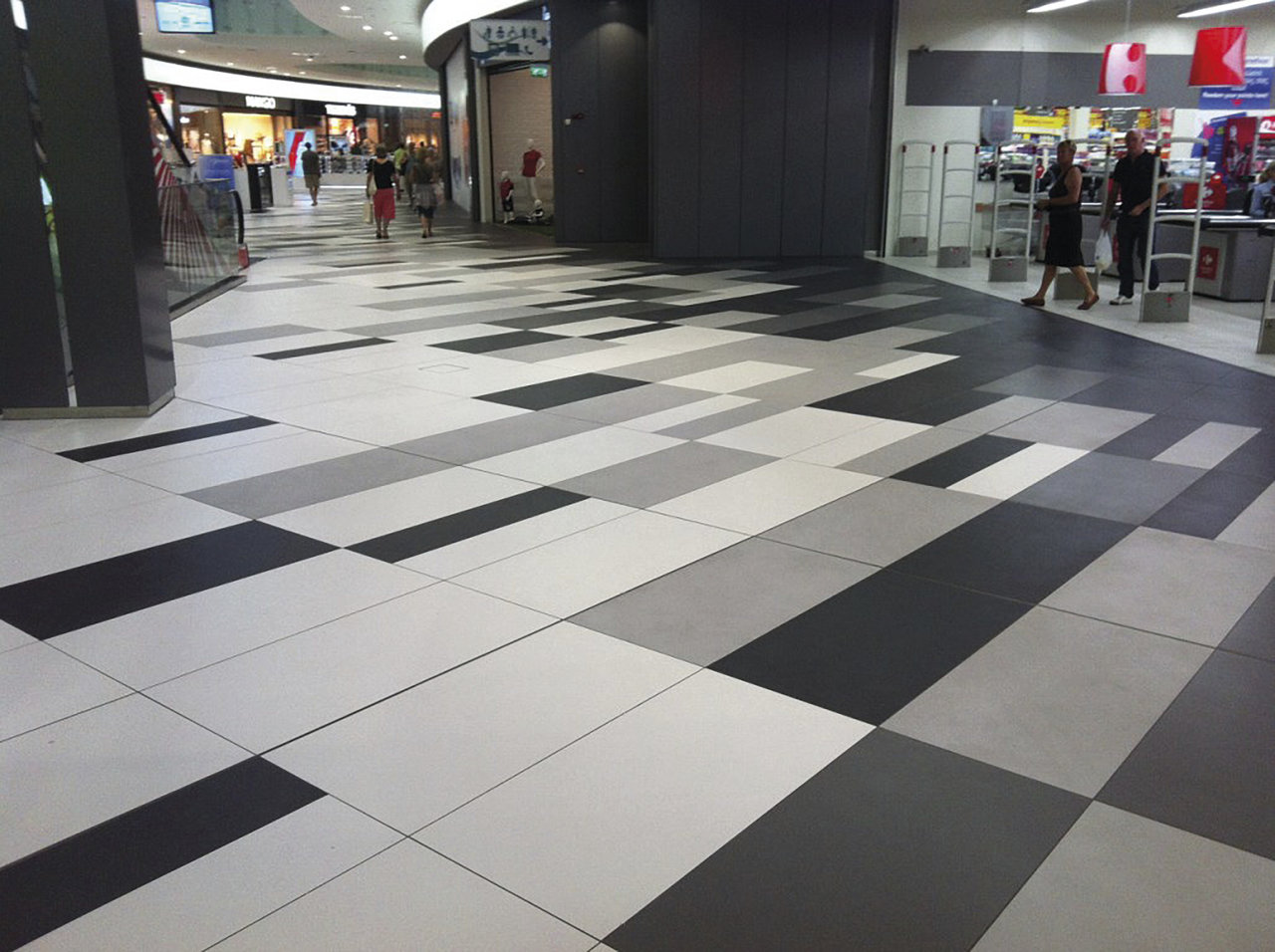 Modern tiled floor in grey, black and white with a geometric pattern.