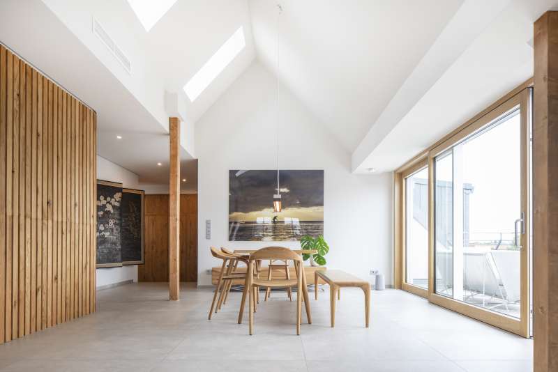 Spacious dining area with bright floor tiles, wooden accents, and ample natural light.