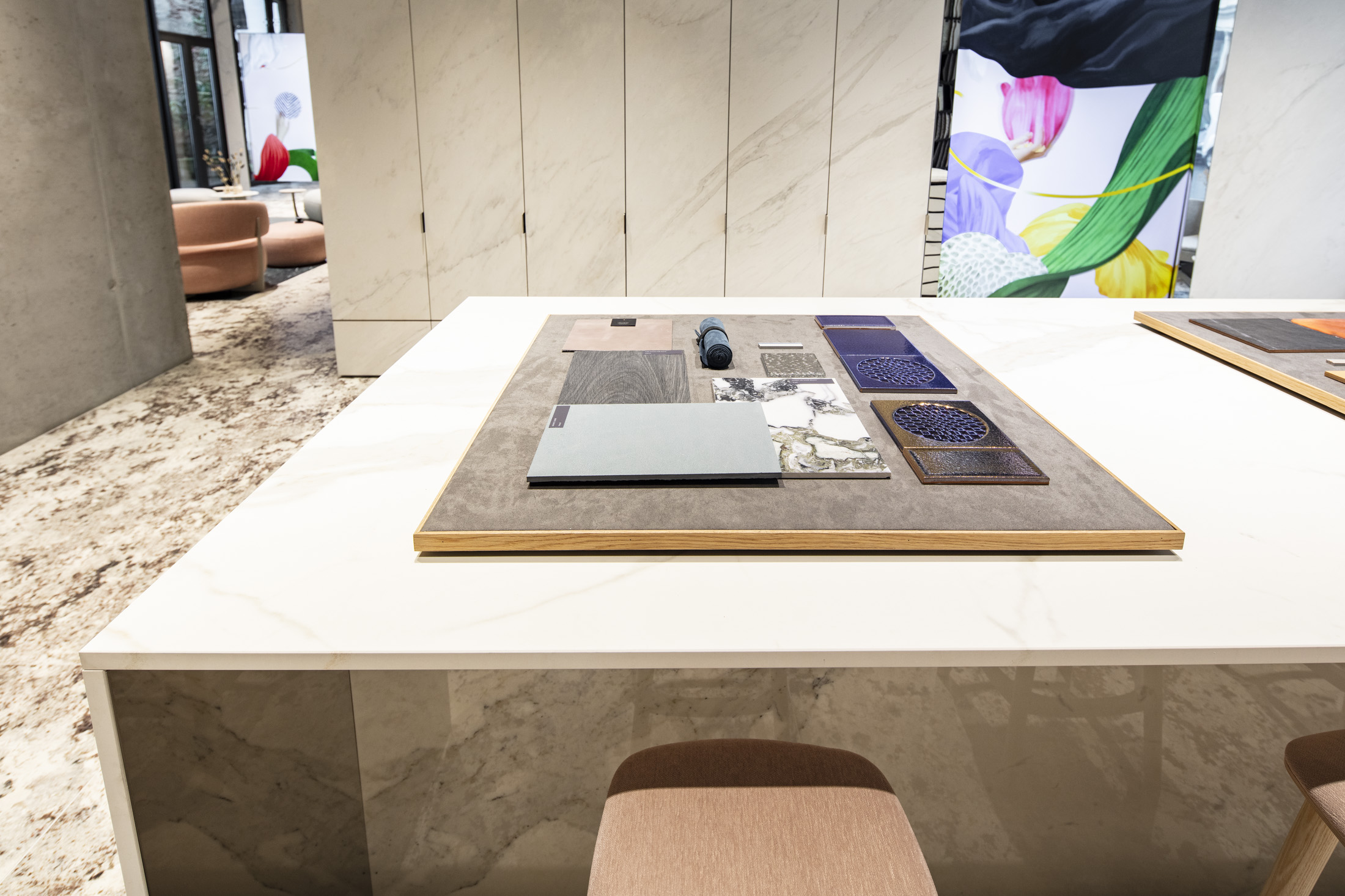 Diverse tile patterns from Porcelaingres and Schöner Wohnen on a showroom display table.