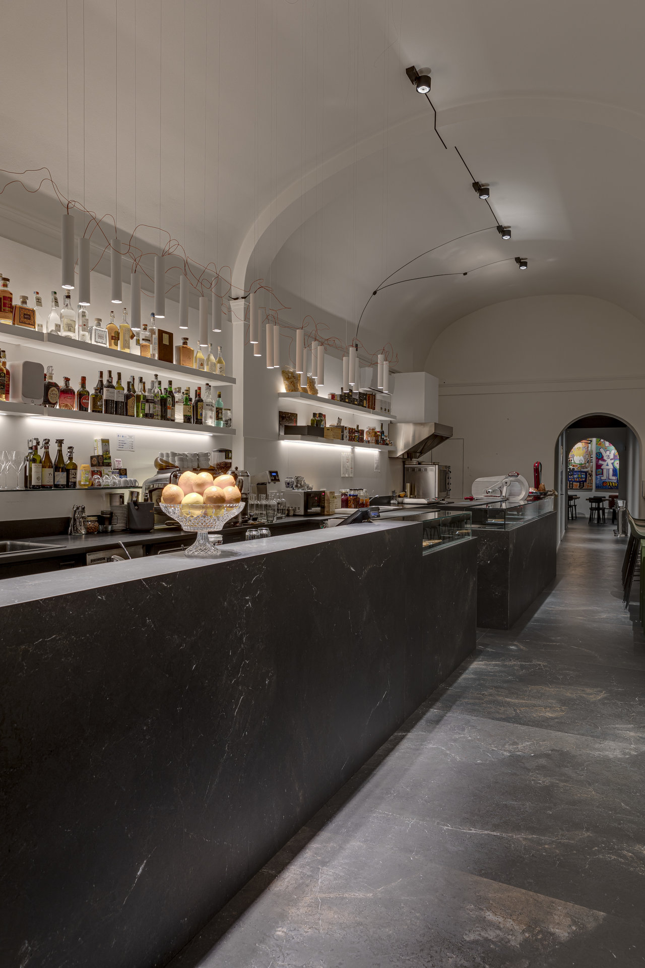 Modern bar with elegant, large-format dark floor tiles and a matching counter.