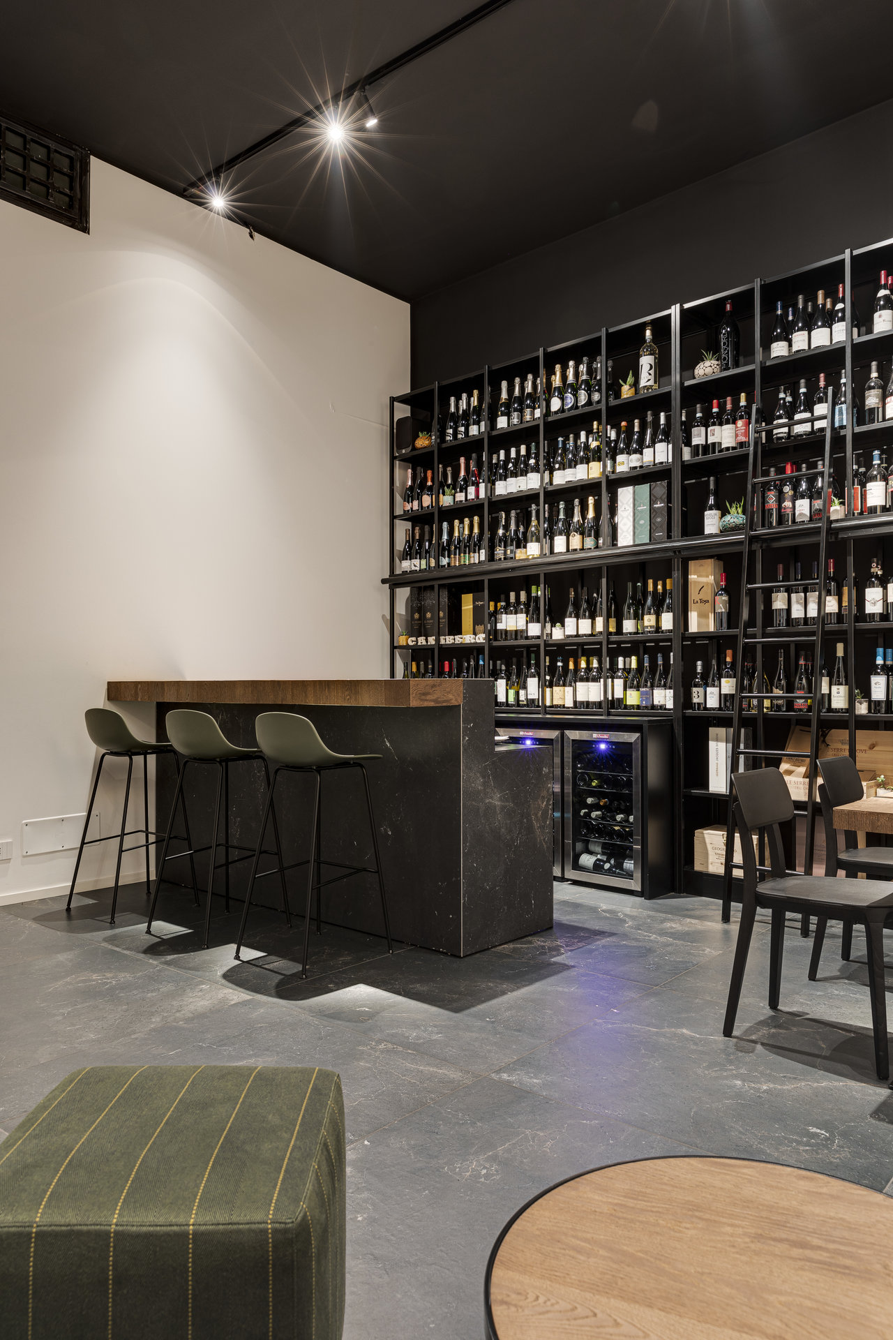 Elegant wine bar with large concrete-look tiles.
