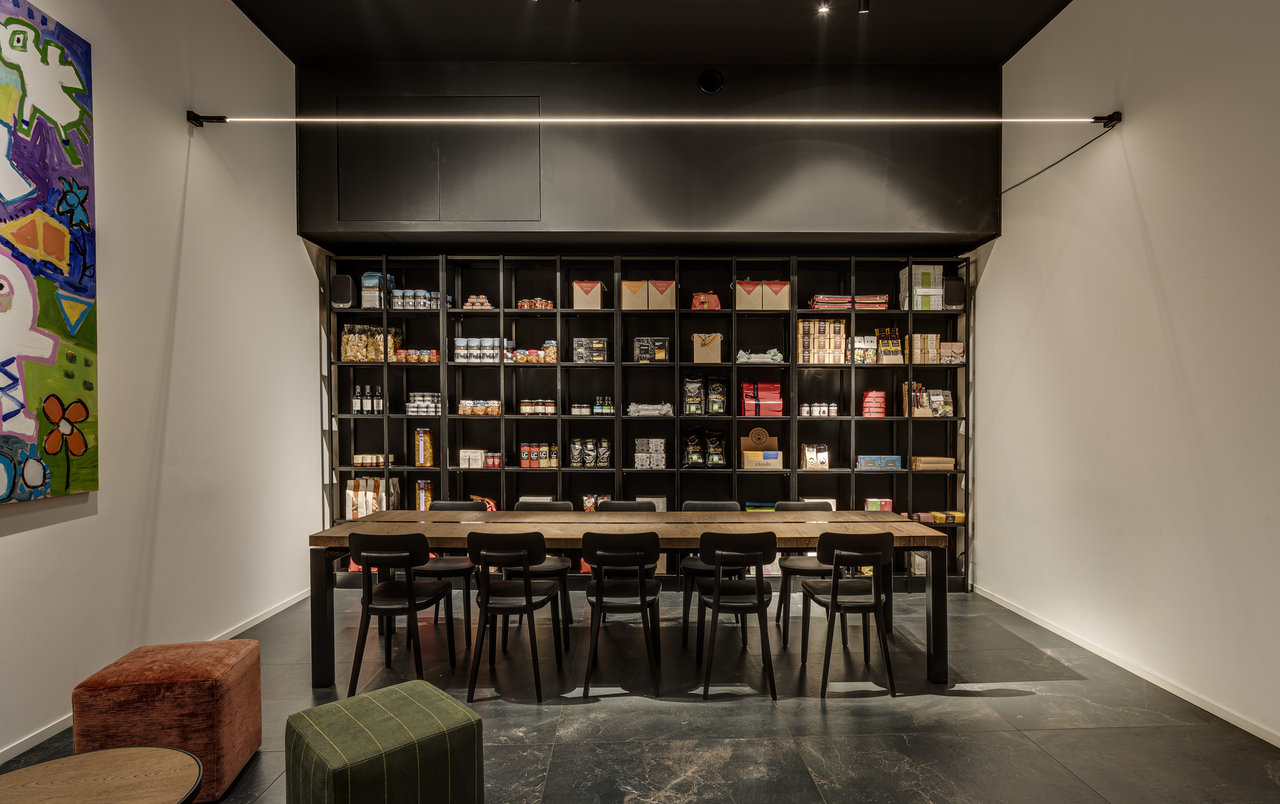 Dark tiled floor in a stylish consultation room with wooden table and shelf.