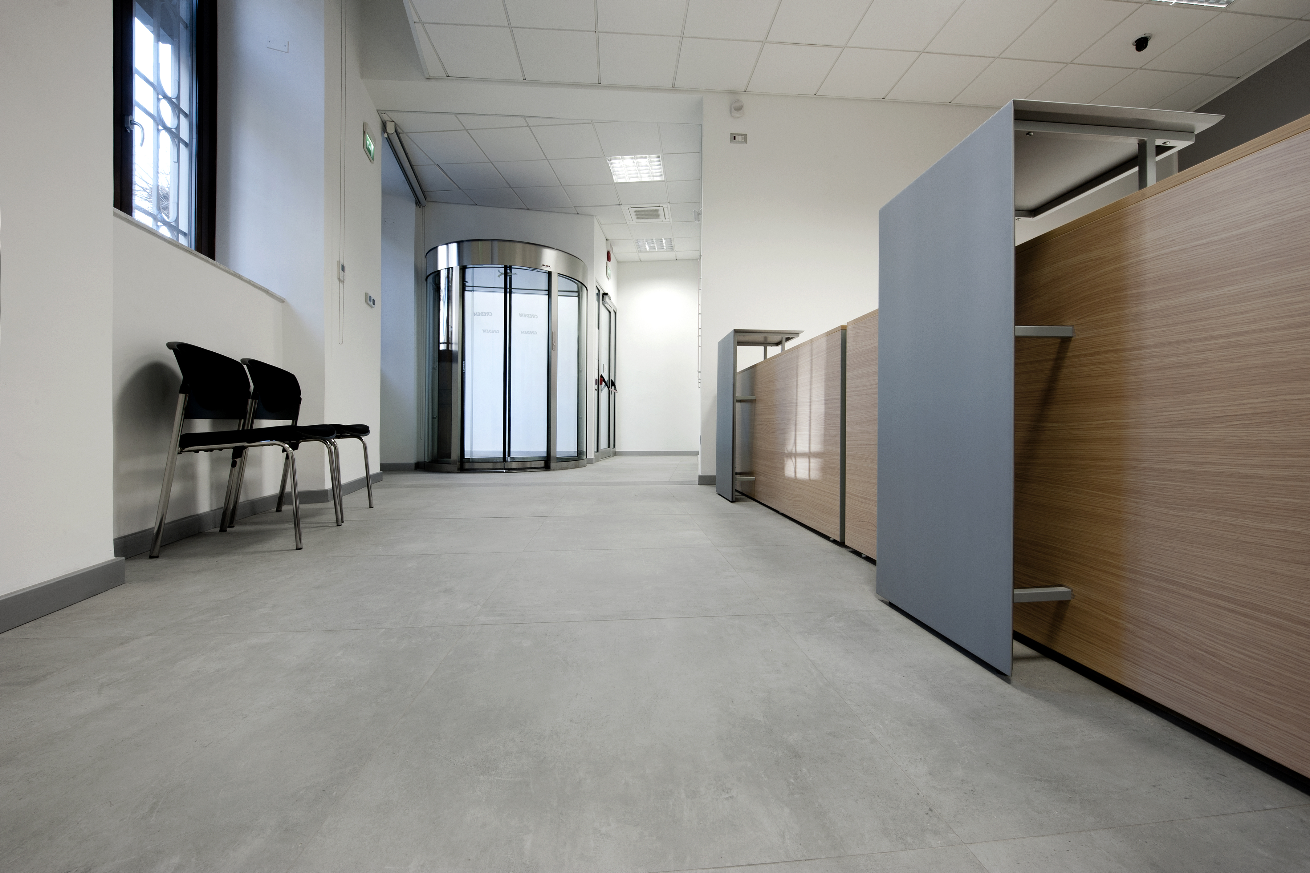 Bright, modern hallway with grey floor tiles and wooden elements.