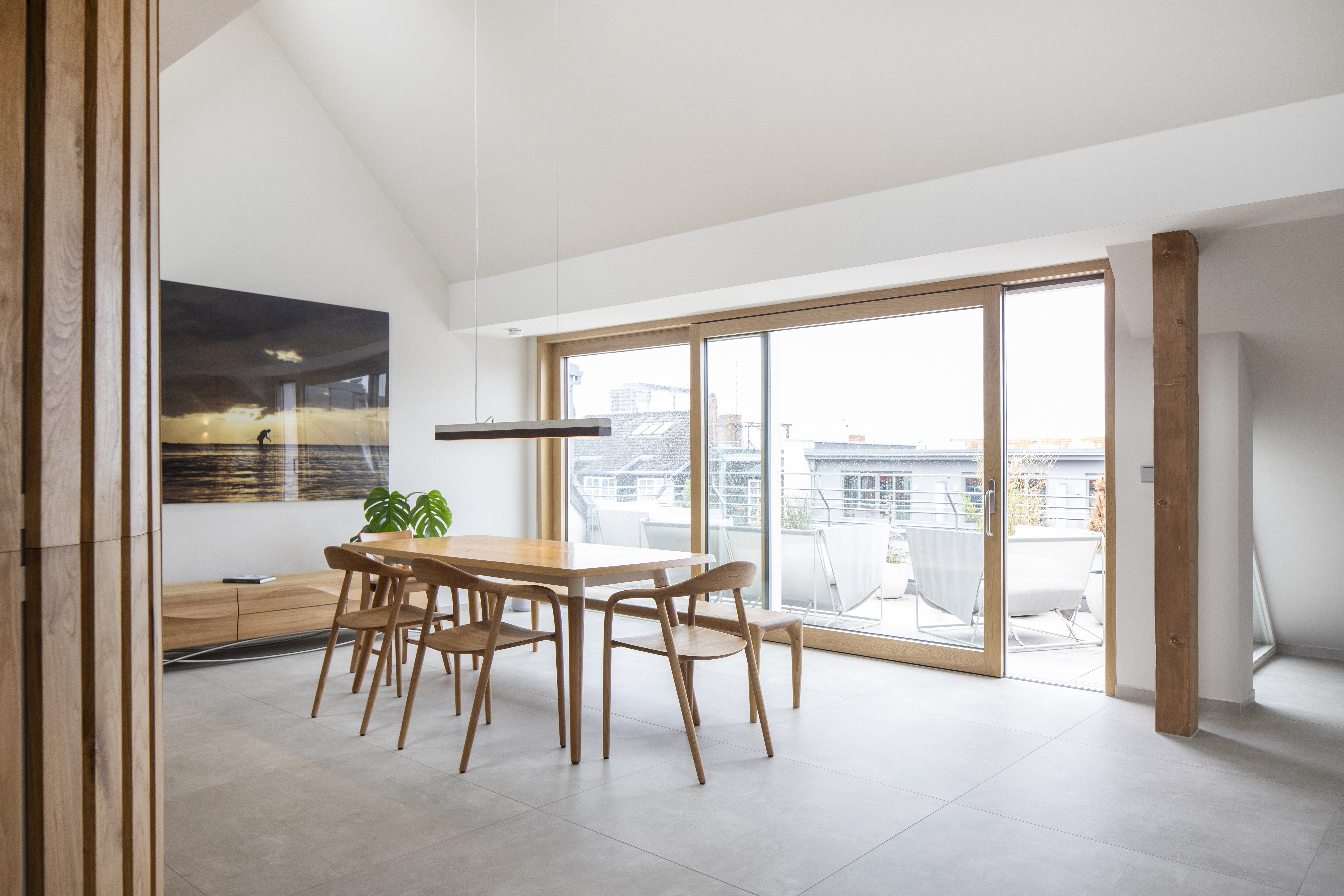 Modern dining area with light grey floor tiles and access to the terrace.