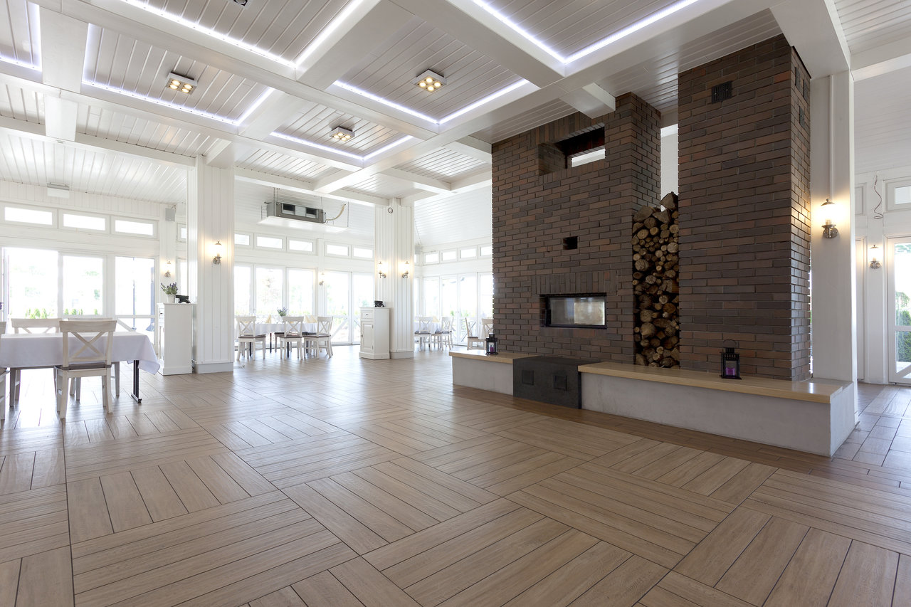 Light wood-effect indoor tiles in a modern room with a fireplace.