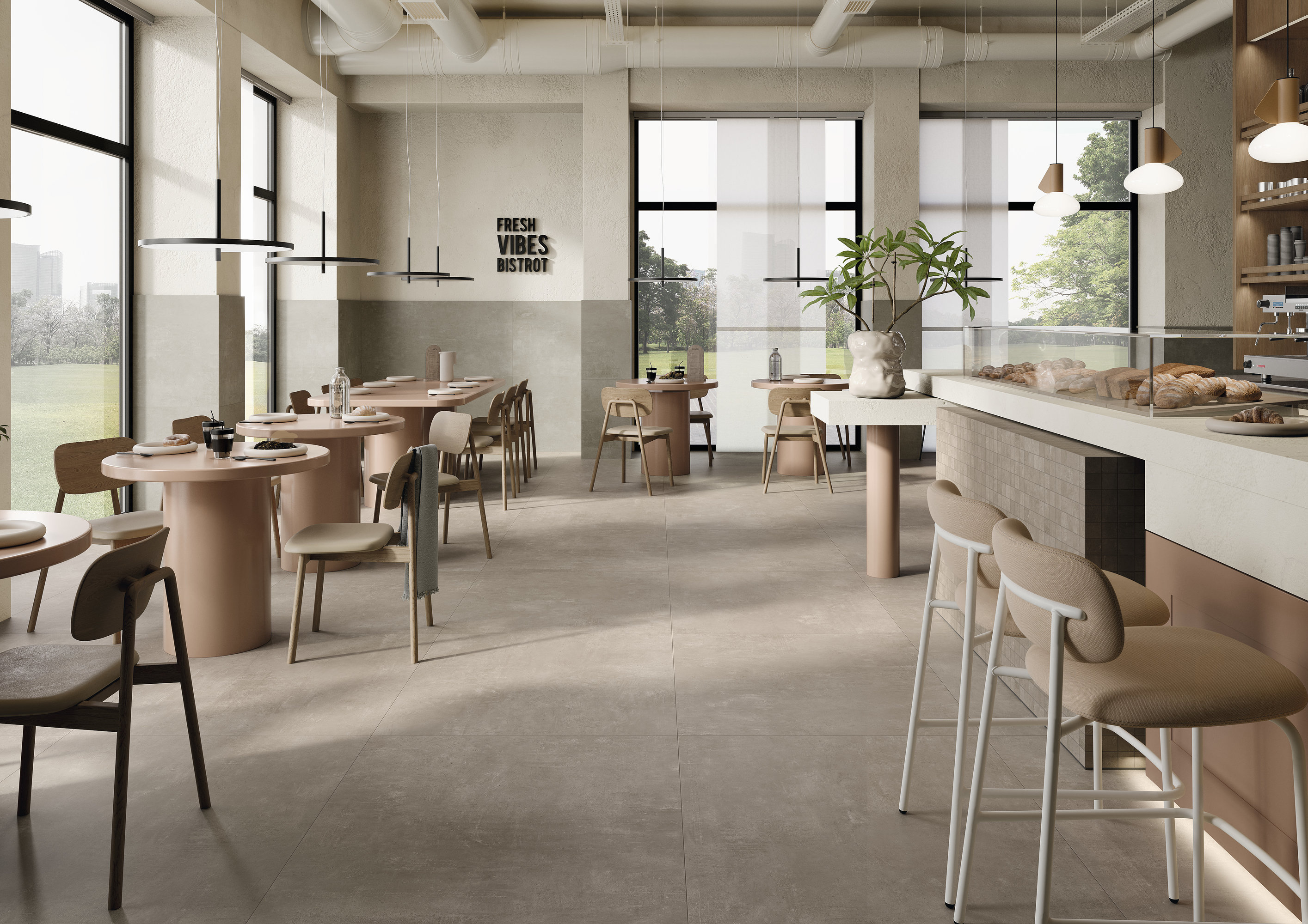 Modern cafe interior with light grey, large-format concrete-look floor tiles.