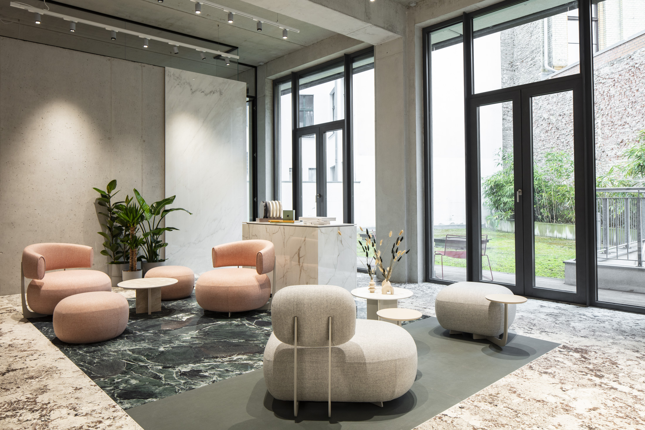 Modern showroom with elegant seating and various marble-look and designer tile floors.