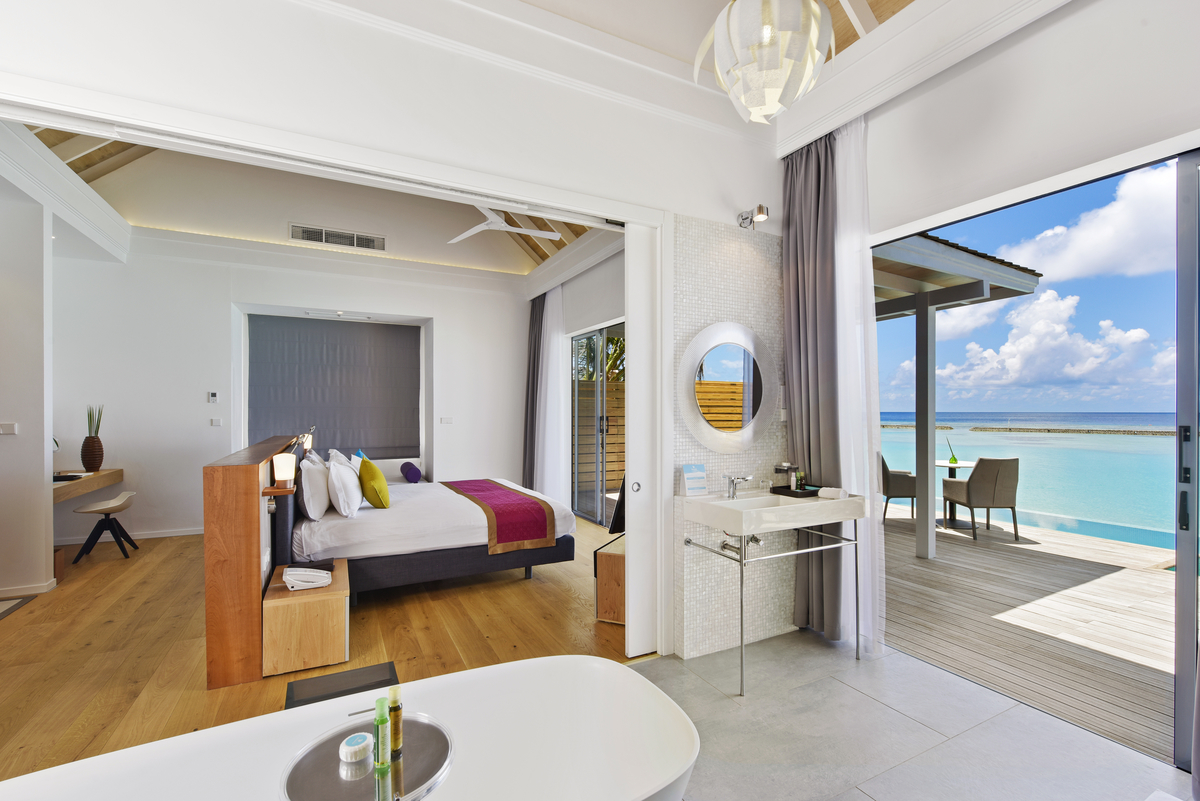 Bright bathroom tiles and wood floor in a luxury suite with sea-view terrace.
