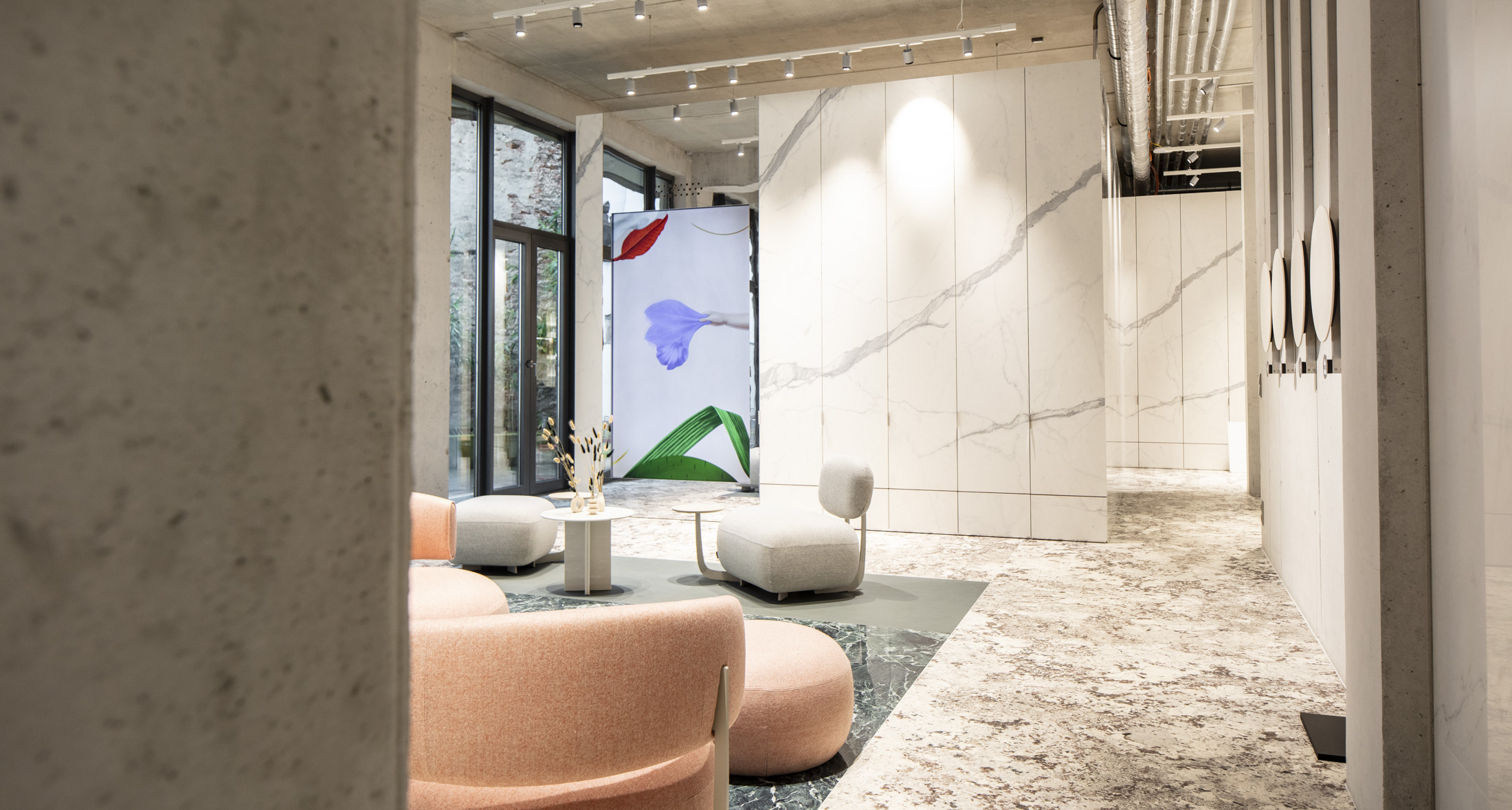 Modern room with large-format light marble-effect tiles on walls and floors, plus stylish lounge furniture.